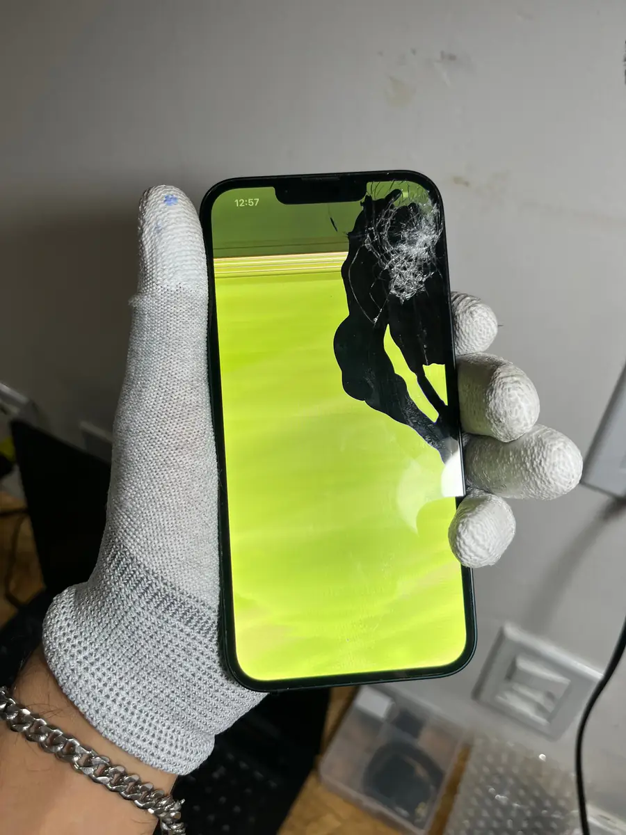 O mesmo iPhone 16 Pro Max antes, com o vidro trincado e a tela falhando em verde.